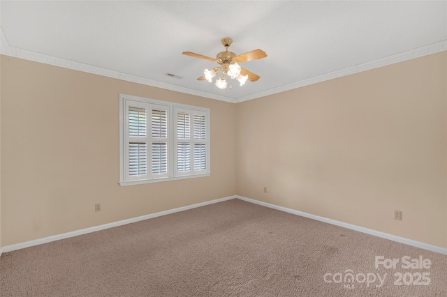 carpeted empty room with baseboards, ornamental molding, a ceiling fan, and visible vents