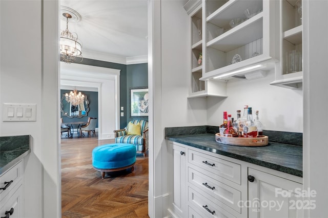 bar with crown molding, pendant lighting, a chandelier, and a dry bar