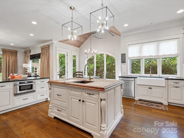 kitchen with a sink, a wealth of natural light, an inviting chandelier, and dishwasher