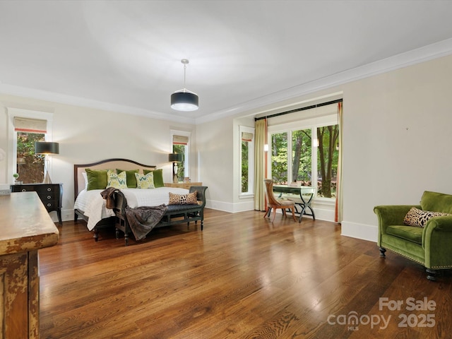 bedroom with crown molding, baseboards, multiple windows, and wood finished floors