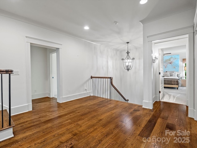 interior space featuring recessed lighting, baseboards, a notable chandelier, and wood finished floors
