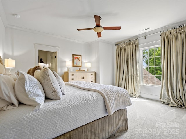 bedroom with ceiling fan, visible vents, light carpet, and ornamental molding