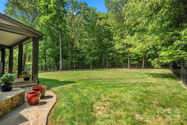 view of yard with a fenced backyard and a wooded view