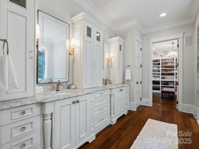 full bath with crown molding, a chandelier, wood finished floors, and vanity