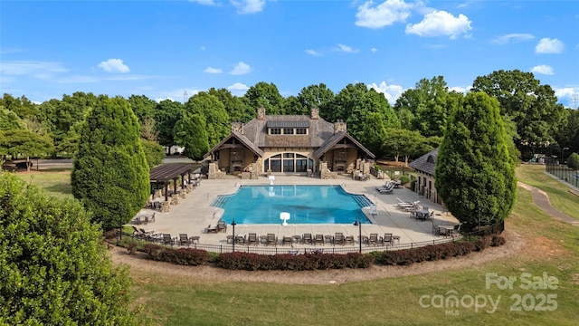 community pool featuring a yard, a patio, and fence