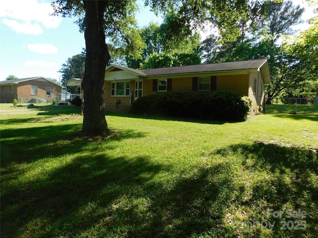 ranch-style home featuring fence and a front yard
