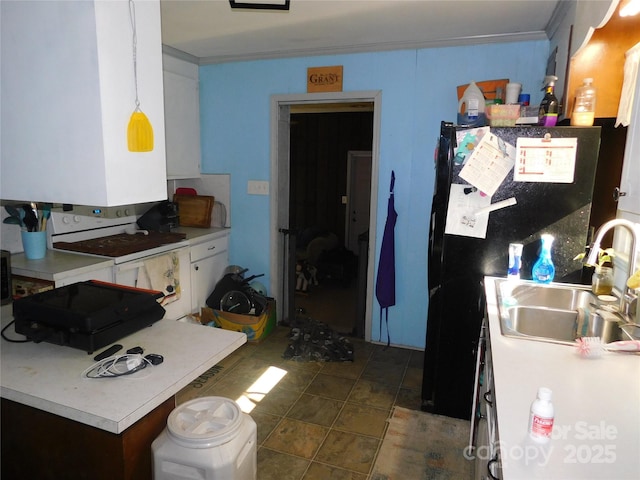 kitchen featuring a sink, freestanding refrigerator, electric range, light countertops, and ornamental molding