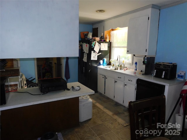 kitchen with a sink, white cabinetry, light countertops, and black appliances