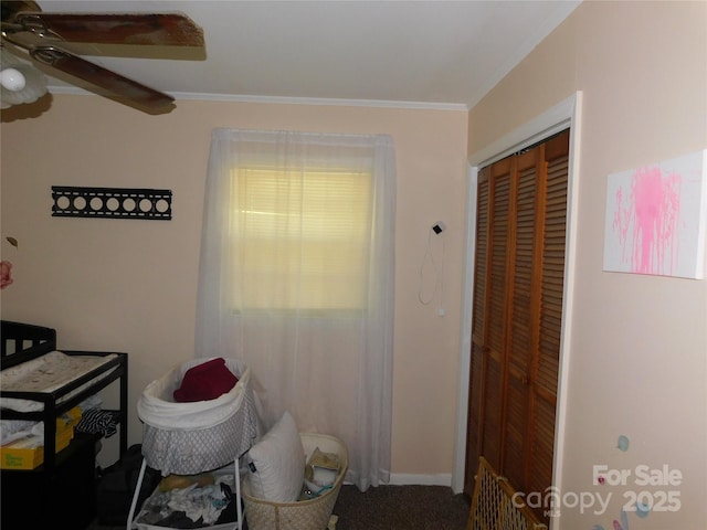 interior space with a closet, baseboards, a ceiling fan, and ornamental molding
