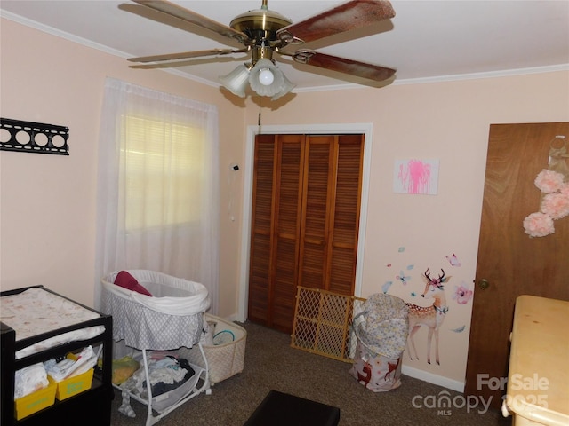 carpeted bedroom with a ceiling fan, ornamental molding, and a closet