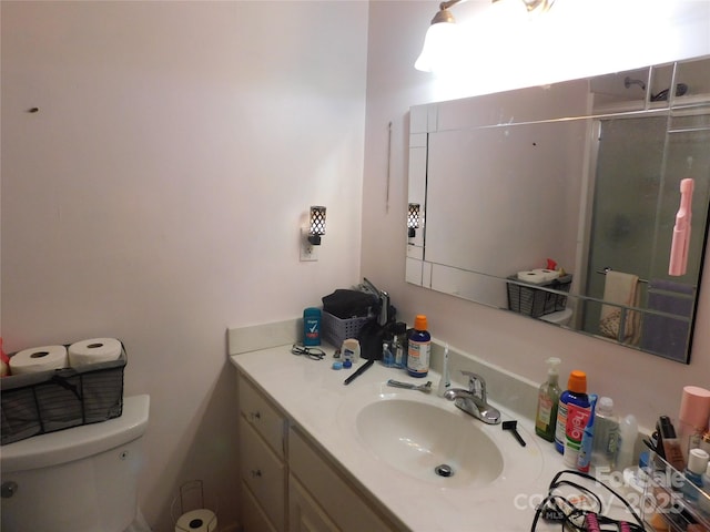 full bath with a shower with shower door, vanity, and toilet