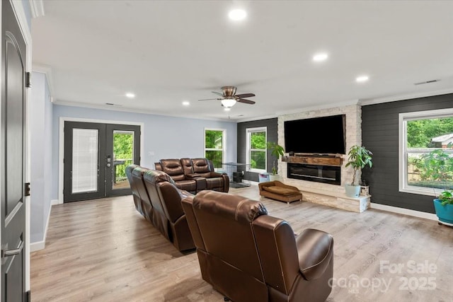 living area with baseboards, a fireplace, and a wealth of natural light