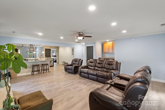 living area featuring ceiling fan, visible vents, baseboards, light wood finished floors, and recessed lighting