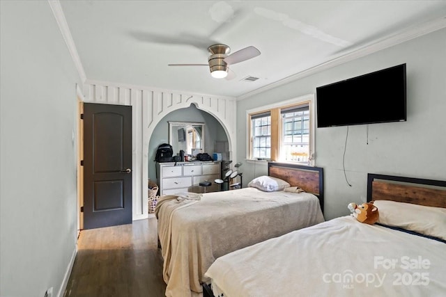 bedroom with visible vents, ornamental molding, baseboards, and wood finished floors