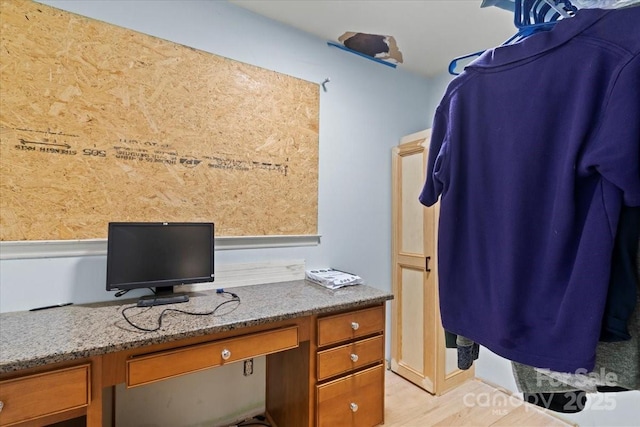 office area with light wood-style flooring and built in desk
