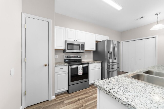 kitchen featuring visible vents, white cabinetry, appliances with stainless steel finishes, and light wood-type flooring