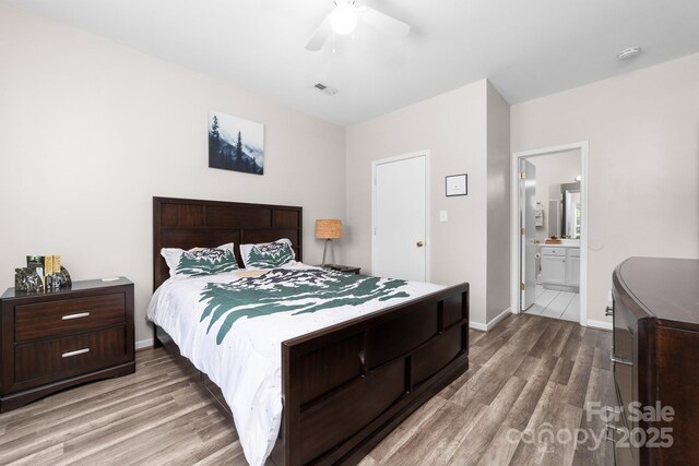 bedroom with ceiling fan, visible vents, light wood-type flooring, baseboards, and ensuite bath