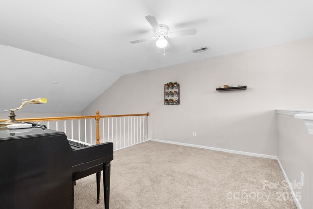 interior space featuring visible vents, a ceiling fan, baseboards, and vaulted ceiling