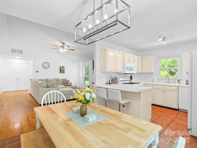 dining space with visible vents, ceiling fan, a healthy amount of sunlight, and vaulted ceiling