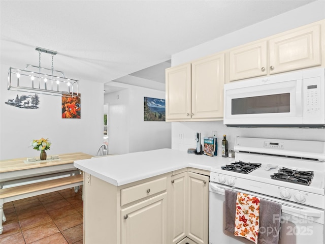 kitchen featuring a peninsula, white appliances, light countertops, light tile patterned floors, and decorative light fixtures