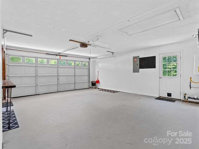 garage with a garage door opener and electric panel