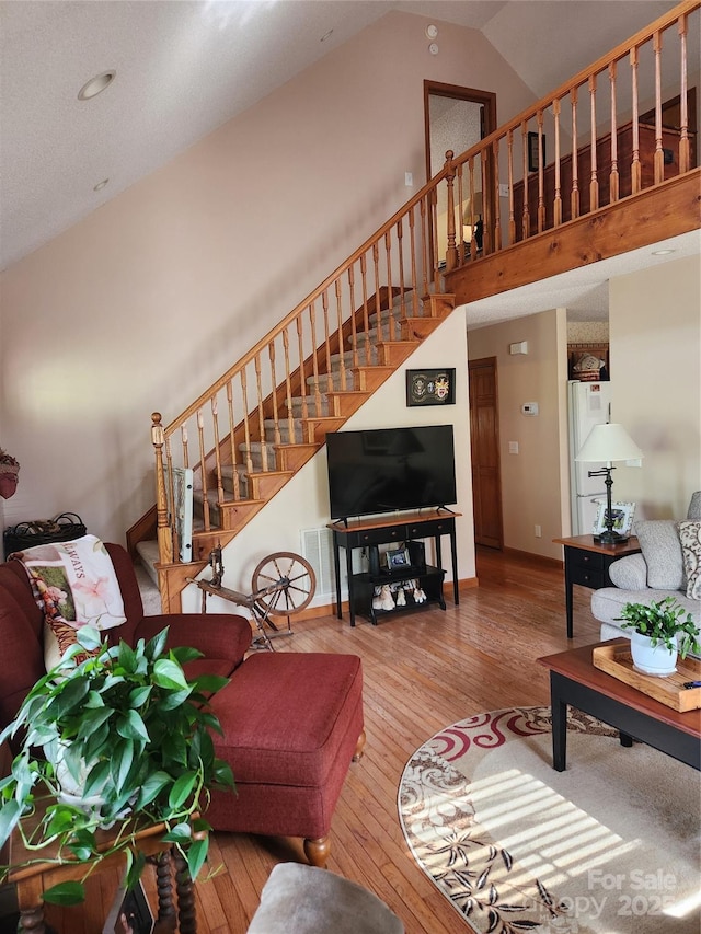 107 Buckner Dr, Roan Mountain, TN 37687 - living room with stairs, high vaulted ceiling, baseboards, and hardwood / wood-style flooring