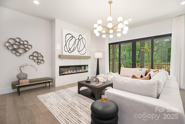 1534 Easy St, Belmont, NC 28012 - living area with wood finished floors, recessed lighting, a glass covered fireplace, a chandelier, and baseboards