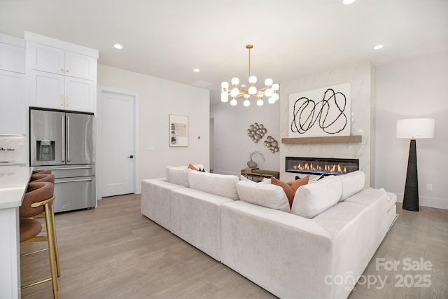 1534 Easy St, Belmont, NC 28012 - living area featuring light wood-style floors, a premium fireplace, a chandelier, and recessed lighting