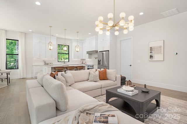 1534 Easy St, Belmont, NC 28012 - living room with a chandelier, healthy amount of natural light, light wood finished floors, recessed lighting, and baseboards