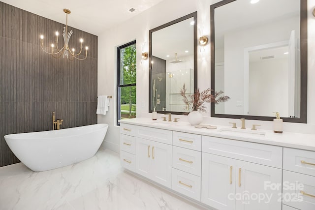 1534 Easy St, Belmont, NC 28012 - full bathroom with marble tiled floors, a shower stall, double vanity, a freestanding tub, and a chandelier