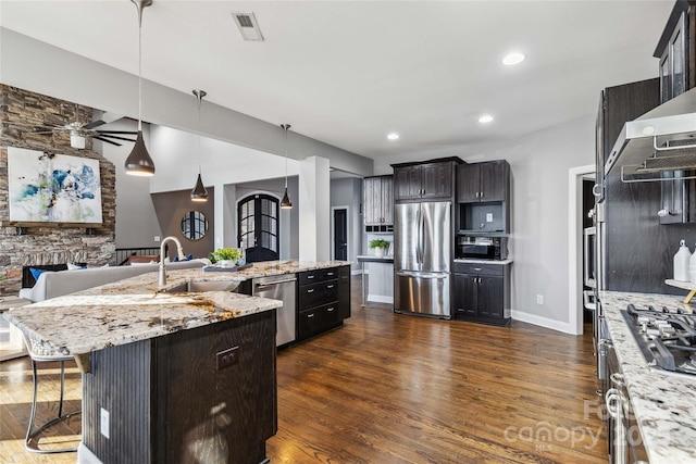 kitchen with dark wood-style flooring, a large island, visible vents, a sink, and stainless steel appliances
