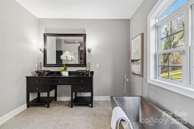 bathroom with baseboards, a wealth of natural light, tile patterned flooring, and vanity