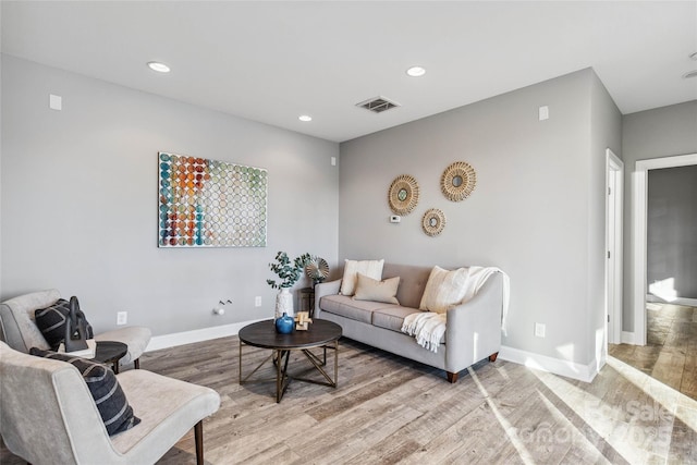 living area featuring light wood-style floors, baseboards, recessed lighting, and visible vents