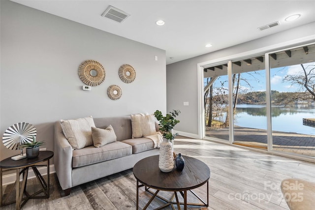 living room with baseboards, recessed lighting, wood finished floors, and visible vents