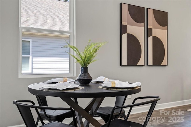 dining room with baseboards and wood finished floors