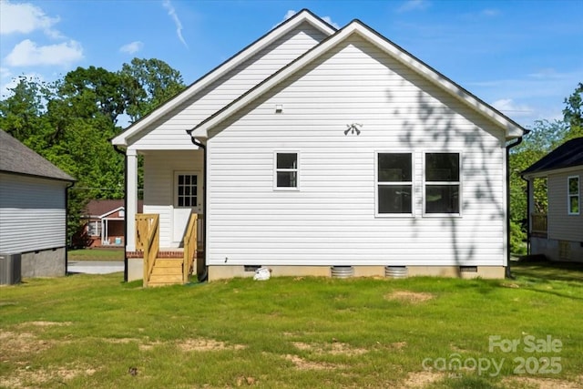 rear view of house featuring a lawn and crawl space