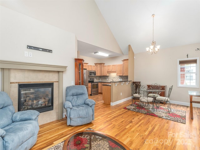 54 Sapling Ln, Waynesville, NC 28786 - living area featuring light wood-style flooring, a chandelier, high vaulted ceiling, and a fireplace