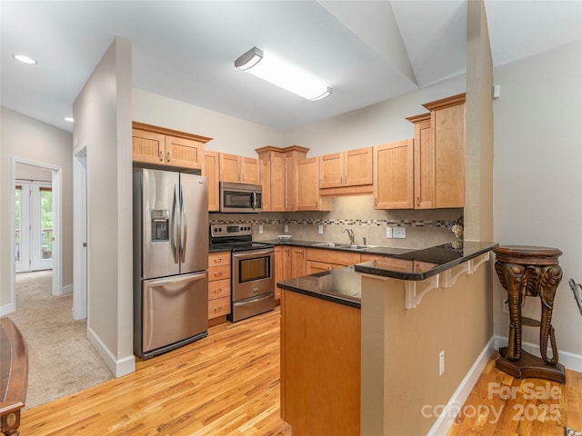 54 Sapling Ln, Waynesville, NC 28786 - kitchen featuring stainless steel appliances, a sink, a peninsula, dark countertops, and a breakfast bar