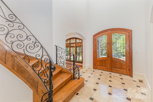 277 Tradition Dr, Mount Gilead, NC 27306 - foyer entrance with french doors, arched walkways, baseboards, a high ceiling, and stairs