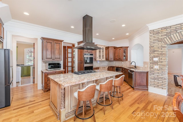 277 Tradition Dr, Mount Gilead, NC 27306 - kitchen featuring a breakfast bar, island range hood, a center island, a sink, and stainless steel appliances