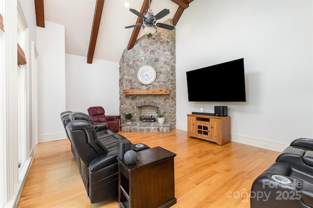 277 Tradition Dr, Mount Gilead, NC 27306 - living room with a ceiling fan, beamed ceiling, a stone fireplace, and wood finished floors