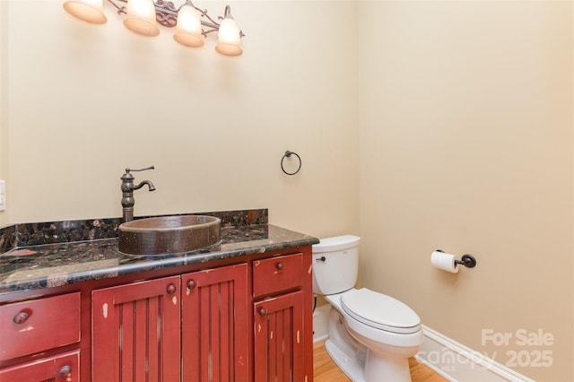 277 Tradition Dr, Mount Gilead, NC 27306 - half bathroom featuring toilet, baseboards, wood finished floors, and vanity