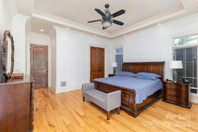 277 Tradition Dr, Mount Gilead, NC 27306 - bedroom featuring crown molding, a raised ceiling, light wood-style flooring, and visible vents