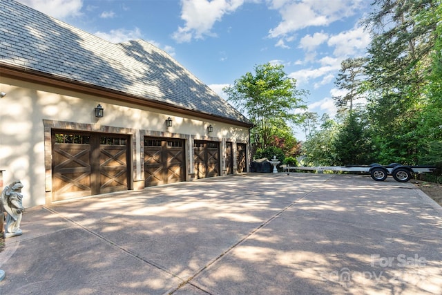 277 Tradition Dr, Mount Gilead, NC 27306 - view of side of property with a garage, a high end roof, stucco siding, and concrete driveway