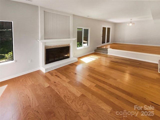 3143 Windbluff Dr, Charlotte, NC 28277 - unfurnished living room with baseboards, wood finished floors, and a fireplace