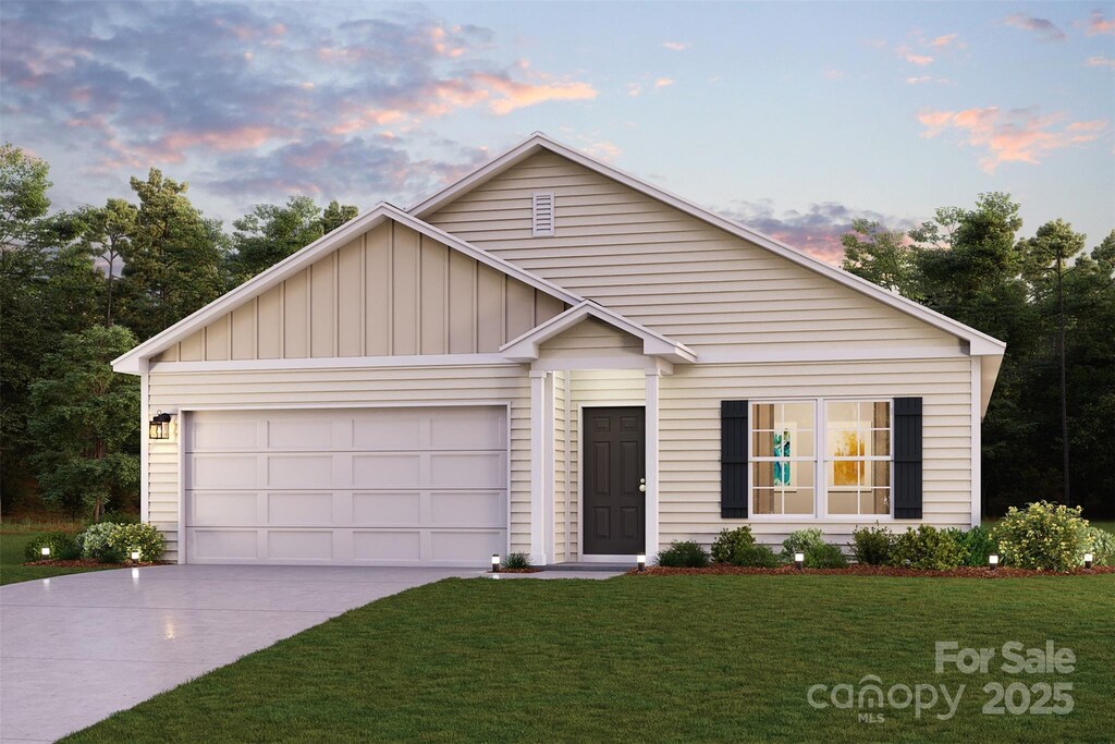 view of front of home featuring a garage, board and batten siding, driveway, and a front lawn