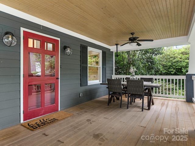 deck with outdoor dining space, a ceiling fan, and covered porch