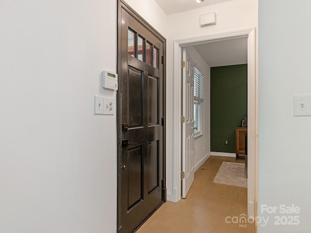 hallway with light wood-style flooring and baseboards