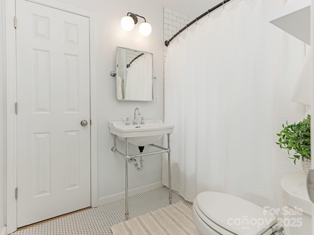 bathroom featuring toilet, baseboards, tile patterned flooring, and curtained shower