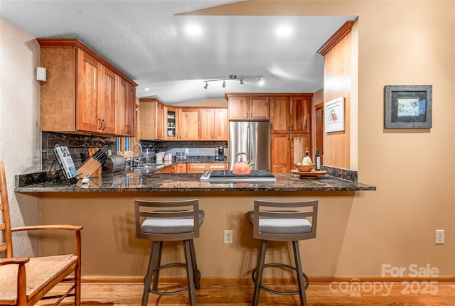 461 Sugar Hollow Rd, Fairview, NC 28730 - kitchen with stainless steel appliances, a peninsula, decorative backsplash, dark stone countertops, and lofted ceiling